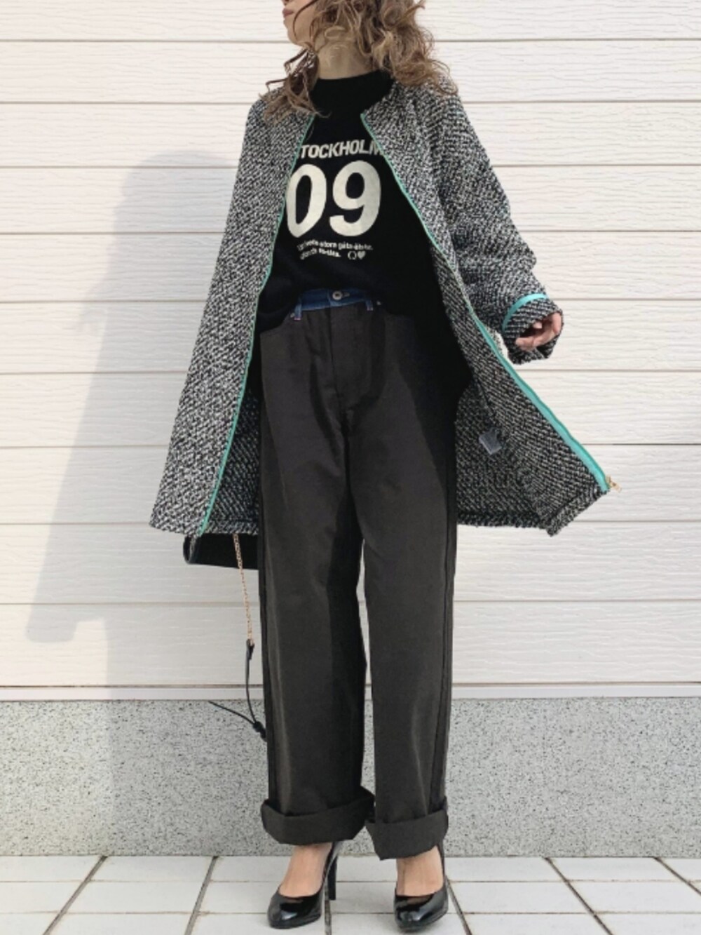 ブラック系のデニムパンツ、ブラック系のショルダーバッグ、ブラック系のTシャツ/カットソーを着用したレディースの秋コーディネートの2枚目の写真