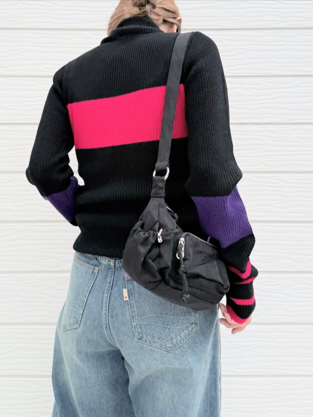 ブルー系のデニムパンツ、ブラック系のショルダーバッグ、ブラック系のスニーカーを着用したレディースの秋コーディネートの4枚目の写真