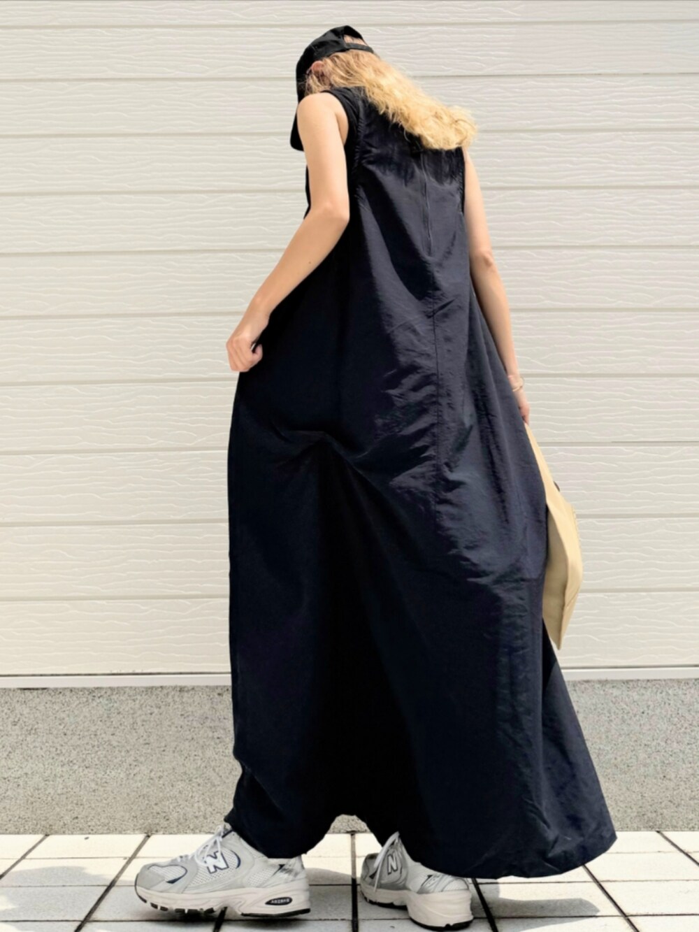 ベージュ系のトートバッグ、シルバー系のスニーカー、ブルー系のワンピースを着用したレディースの夏コーディネートの4枚目の写真