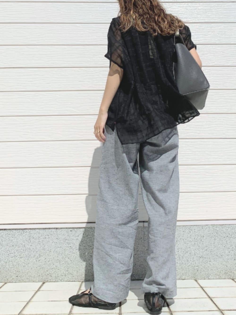 グレー系のトートバッグ、グレー系のその他パンツ、ブラック系のパンプスを着用したレディースの春コーディネートの2枚目の写真