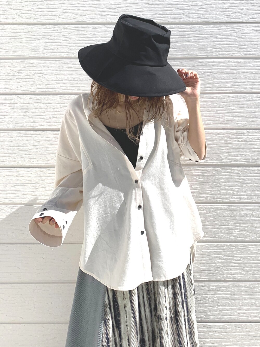 ホワイト系のシャツ/ブラウス、ベージュ系のスカート、ブラック系のサンダルを着用したレディースの春コーディネートの3枚目の写真