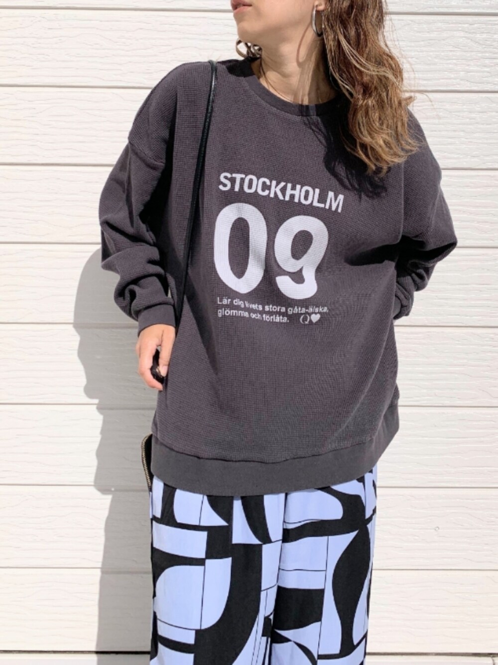 ブラック系のショルダーバッグ、シルバー系のスニーカー、パープル系のその他パンツを着用したレディースの秋コーディネートの4枚目の写真