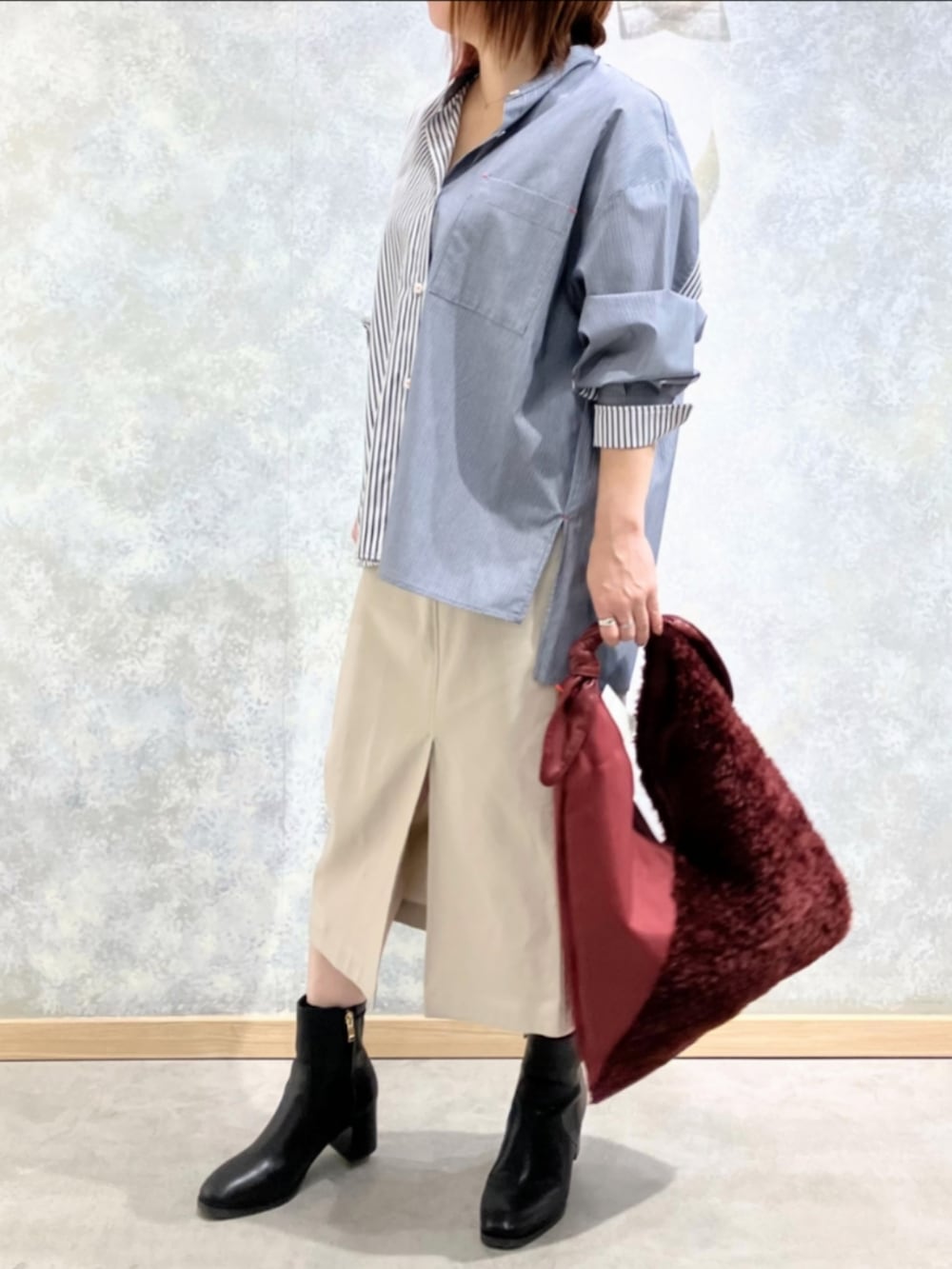 レッド系のトートバッグ、ベージュ系のスカート、ブルー系のシャツ/ブラウスを着用したレディースの冬コーディネートの3枚目の写真