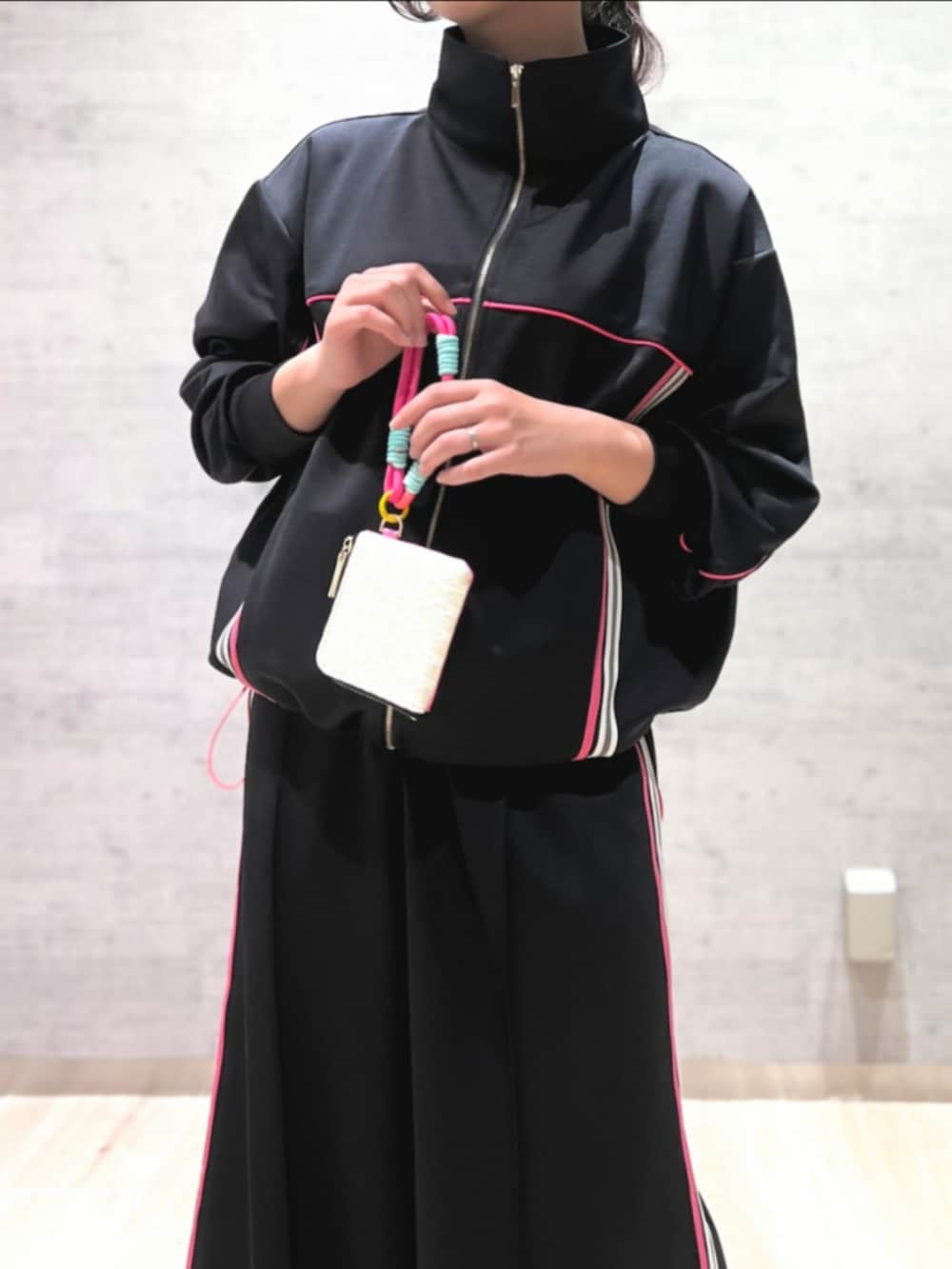 シルバー系のスニーカー、ブラック系のスカート、ブラック系のその他アウターを着用したレディースの春コーディネートの3枚目の写真