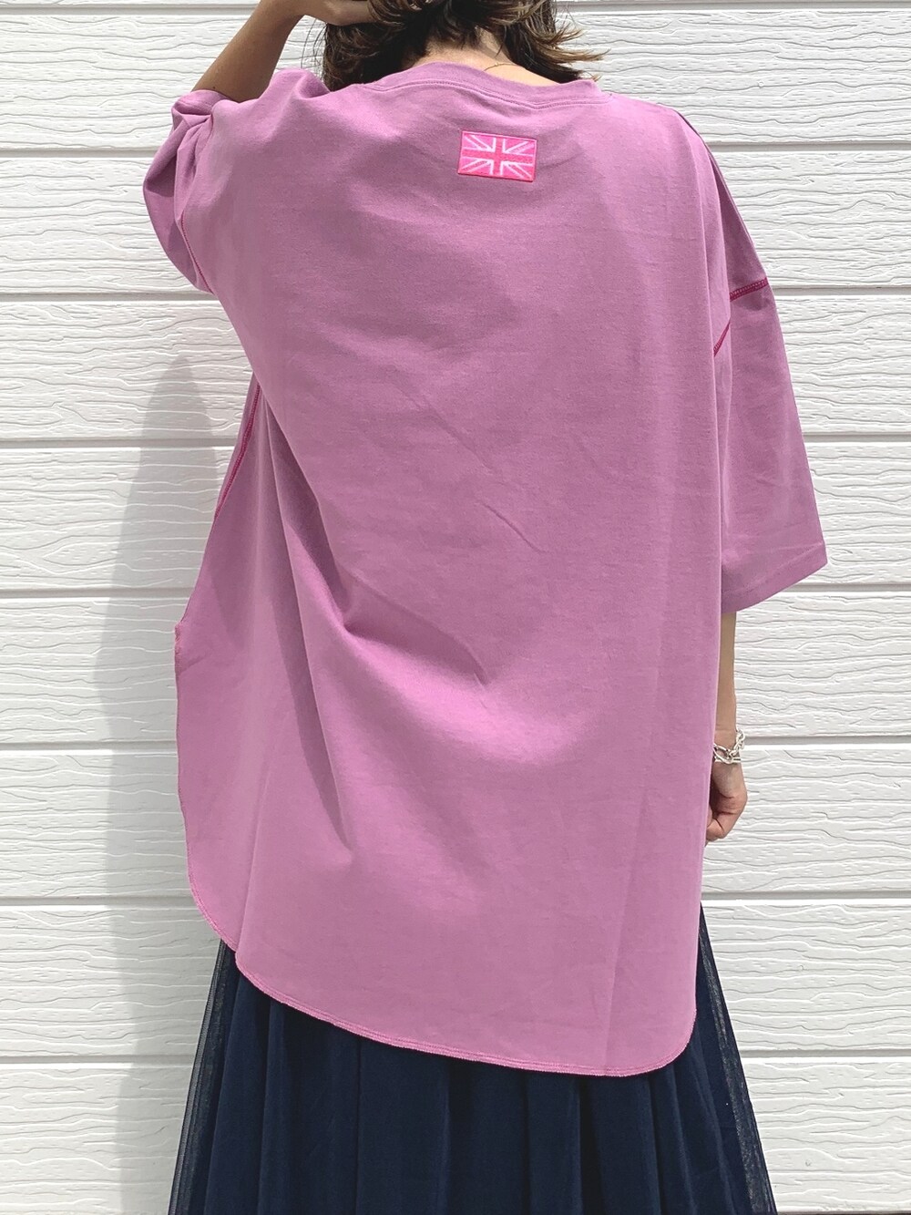 ブルー系のスカート、ホワイト系のスニーカー、パープル系のTシャツ/カットソーを着用したレディースの夏コーディネートの3枚目の写真