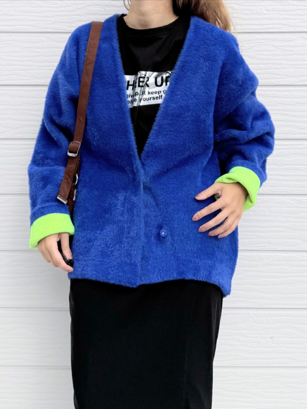 ブラック系のスカート、ブルー系のカーディガン/ボレロ、ブラック系のTシャツ/カットソーを着用したレディースの秋コーディネートの4枚目の写真