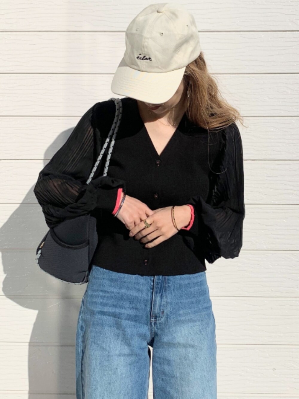 ブルー系のデニムパンツ、ホワイト系のスニーカー、ブルー系のトートバッグを着用したレディースの冬コーディネートの3枚目の写真