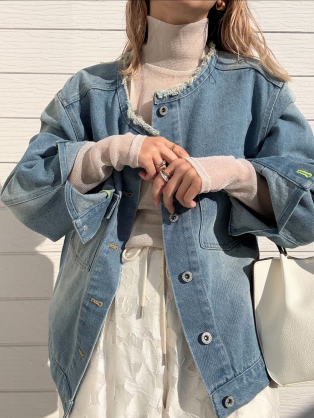 ブルー系のデニムジャケット、ホワイト系のトートバッグ、ホワイト系のTシャツ/カットソーを着用したレディースの冬コーディネートの5枚目の写真