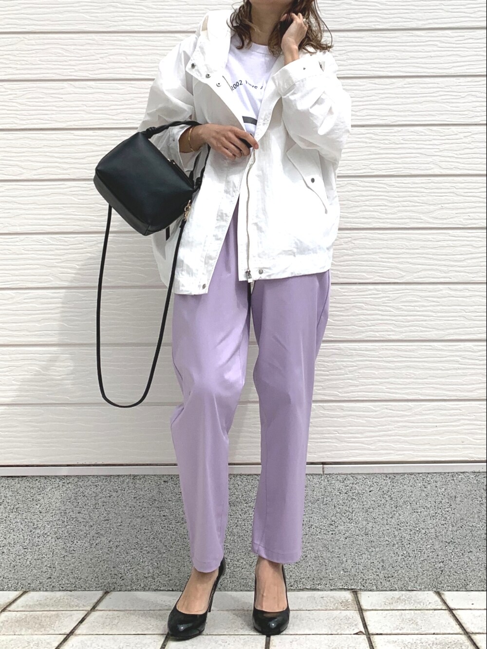 パープル系のその他パンツ、ホワイト系のマウンテンパーカー、ブラック系のハンドバッグを着用したレディースの春コーディネートの2枚目の写真