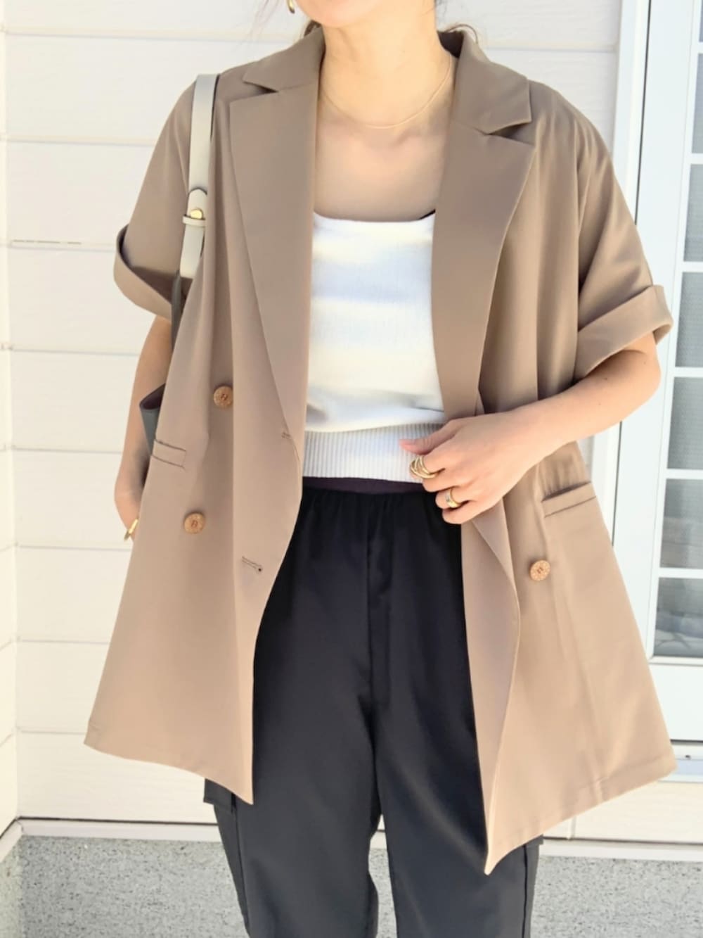 ブラック系のパンプス、ブラック系のカーゴパンツ、ベージュ系のテーラードジャケットを着用したレディースの春コーディネートの4枚目の写真