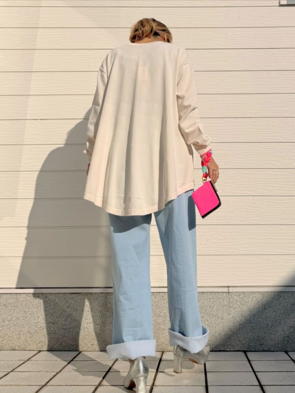 ブルー系のデニムパンツ、グレー系のタンクトップ、ベージュ系のカーディガン/ボレロを着用したレディースの冬コーディネートの3枚目の写真