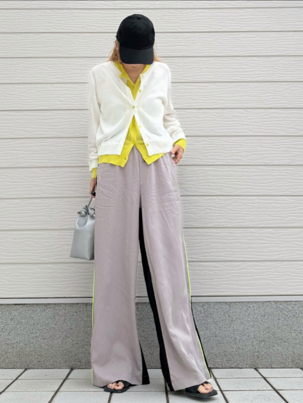 ベージュ系のその他パンツ、ホワイト系のカーディガン/ボレロ、シルバー系のトートバッグを着用したレディースの春コーディネートの2枚目の写真