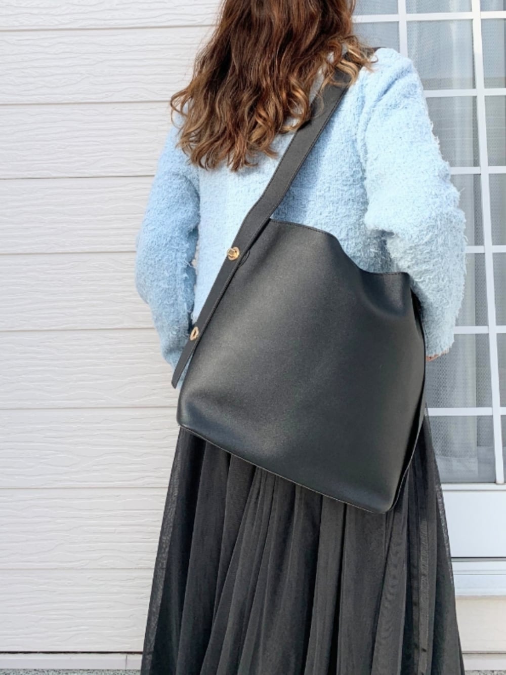 グレー系のスカート、シルバー系のスニーカー、ブルー系のカーディガン/ボレロを着用したレディースの冬コーディネートの4枚目の写真