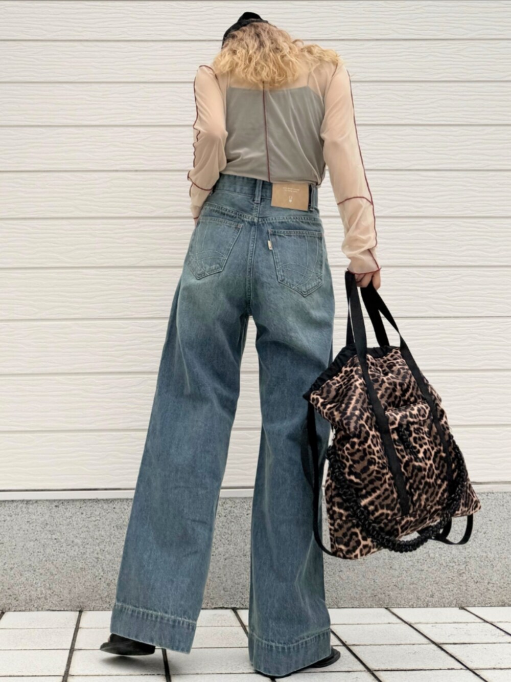 ベージュ系のTシャツ/カットソー、その他のトートバッグ、ブルー系のデニムパンツを着用したレディースの秋コーディネートの3枚目の写真