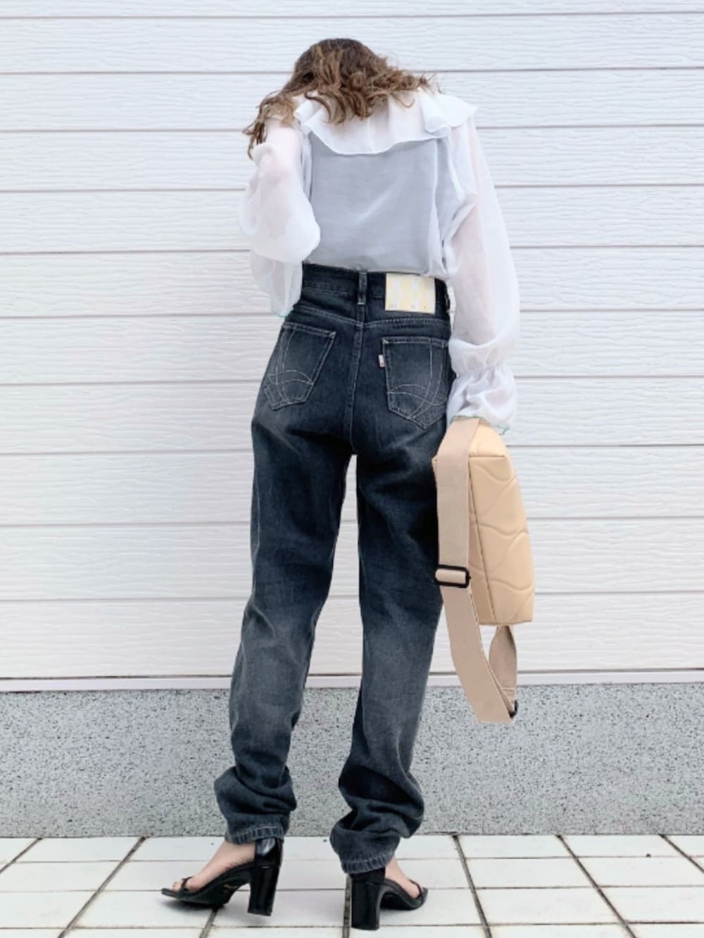 ホワイト系のシャツ/ブラウス、ベージュ系のクラッチバッグ、グレー系のデニムパンツを着用したレディースの春コーディネートの3枚目の写真