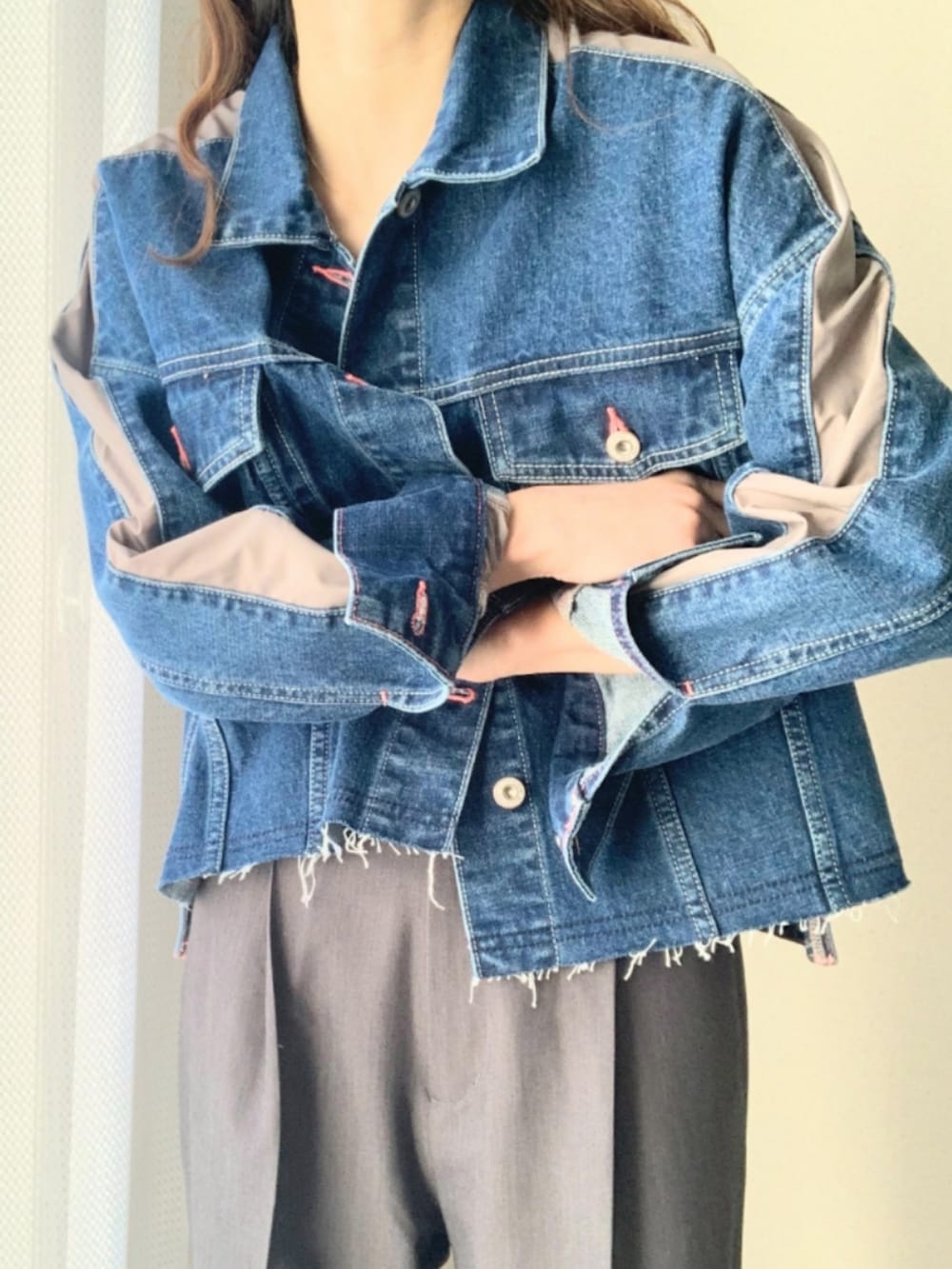 グレー系のスラックス、ブルー系のデニムジャケット、ブラック系のキャミソールを着用したレディースの冬コーディネートの5枚目の写真