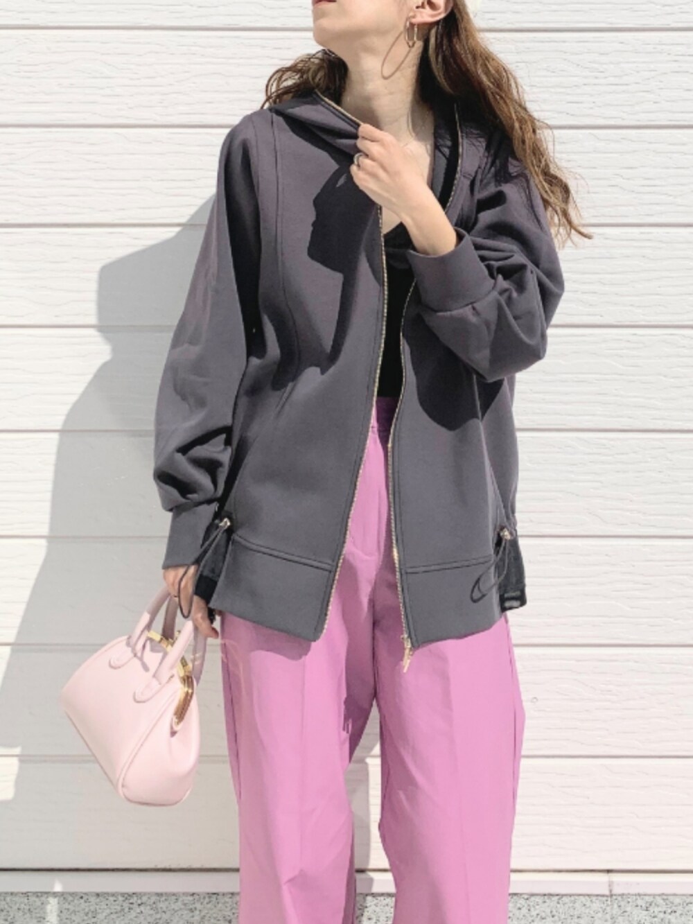 ブラック系のキャミソール、ピンク系のショルダーバッグ、グレー系のパーカーを着用したレディースの春コーディネートの3枚目の写真