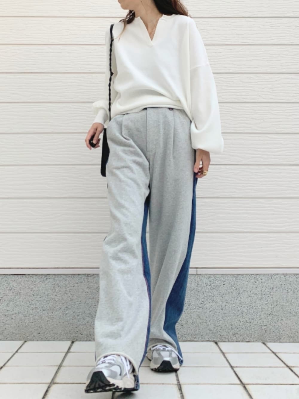 グレー系のデニムパンツ、ブラック系のショルダーバッグ、シルバー系のスニーカーを着用したレディースの冬コーディネートの2枚目の写真