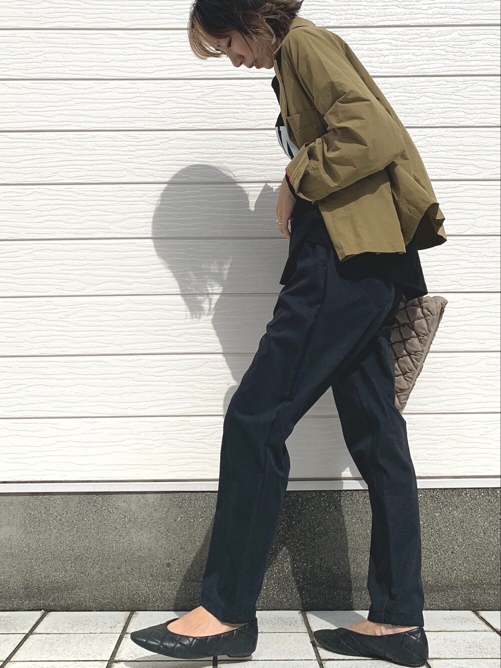 ベージュ系のショルダーバッグ、ベージュ系のブルゾン、ブラック系のTシャツ/カットソーを着用したレディースの夏コーディネートの3枚目の写真