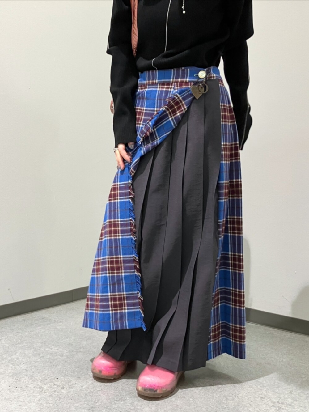 ブルー系のスカート、ブラック系のニット/セーター、ピンク系のボストンバッグを着用したレディースの秋コーディネートの4枚目の写真