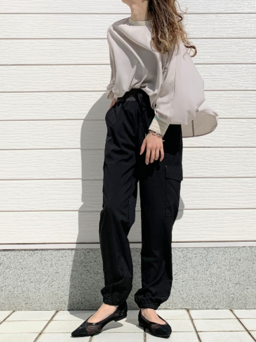 ベージュ系のシャツ/ブラウス、ブラック系のカーゴパンツを着用したレディースの春コーディネートの2枚目の写真