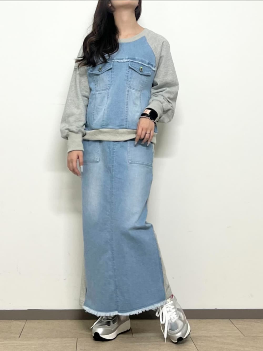 シルバー系のスニーカー、ブルー系のスカート、ブルー系のスウェットを着用したレディースの冬コーディネートの2枚目の写真