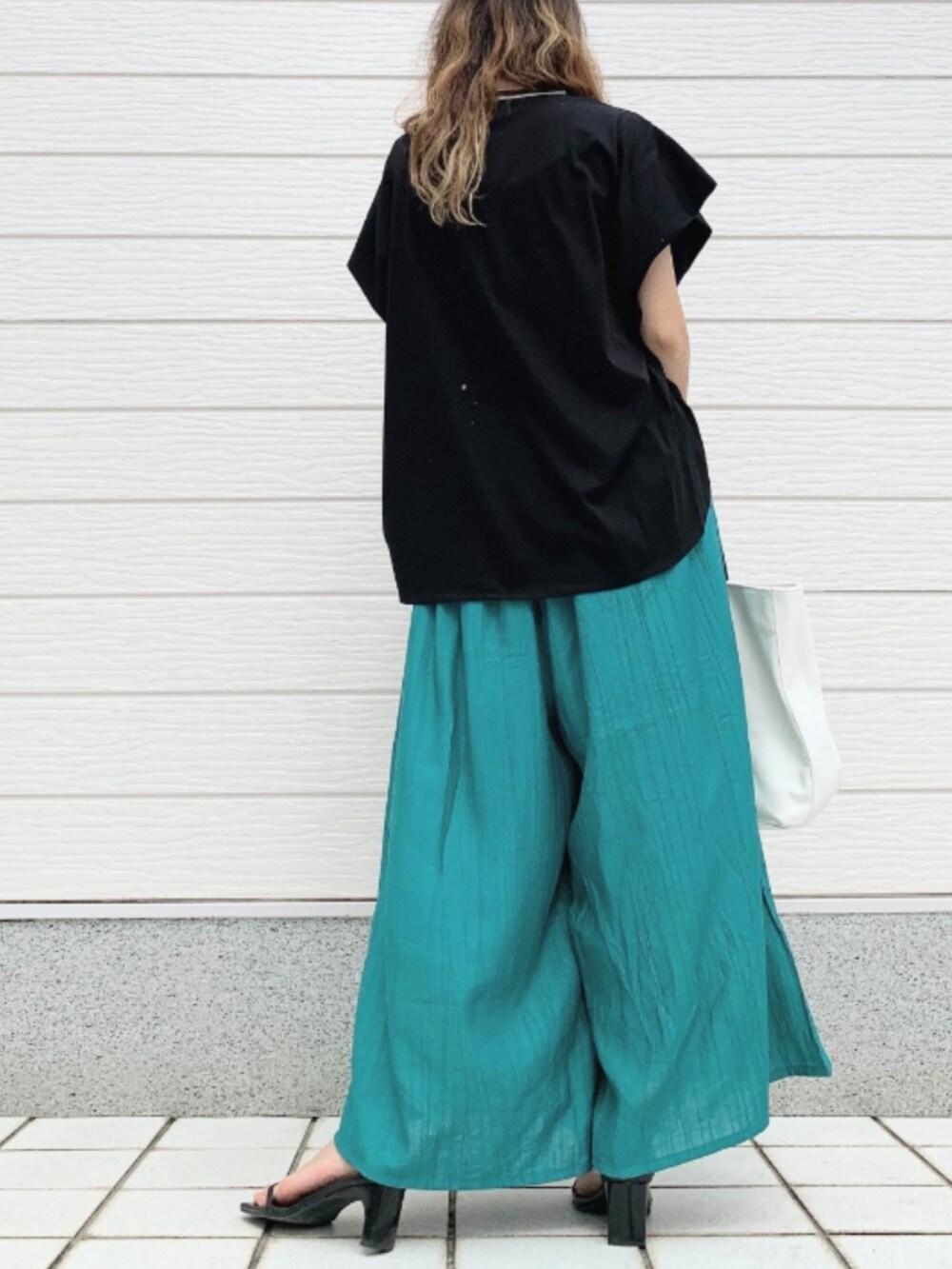 ホワイト系のトートバッグ、グリーン系のその他パンツ、ブラック系のTシャツ/カットソーを着用したレディースの夏コーディネートの2枚目の写真