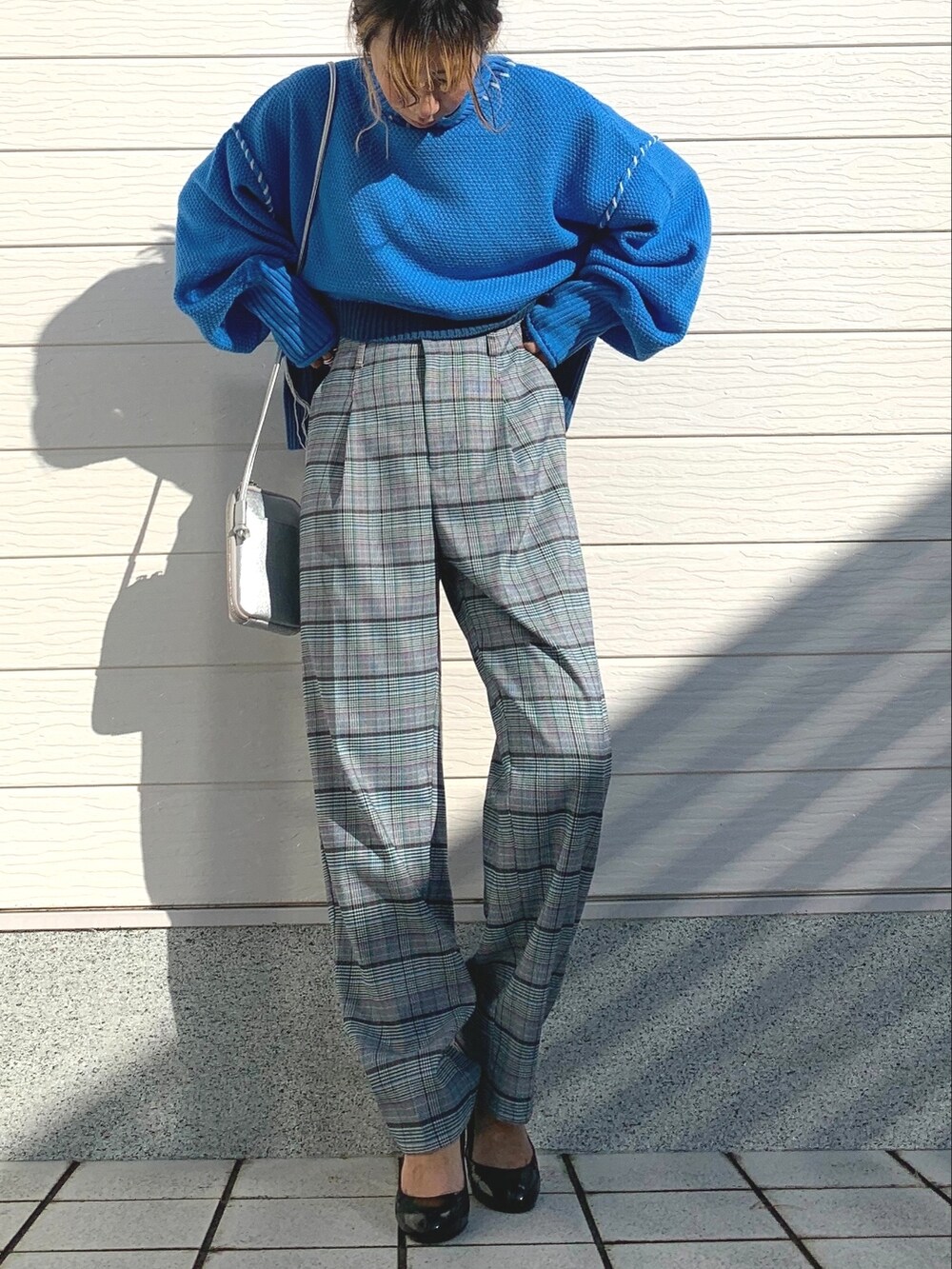 ブルー系のニット/セーター、シルバー系のショルダーバッグ、ブラウン系のその他パンツを着用したレディースの秋コーディネートの2枚目の写真