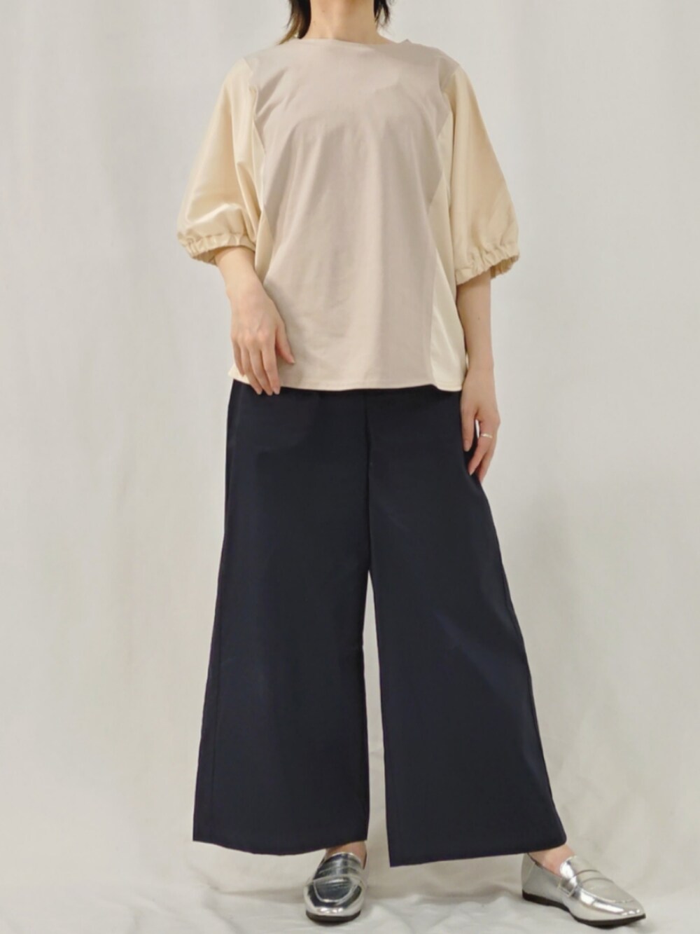 ブルー系のスラックス、シルバー系のローファー、ベージュ系のTシャツ/カットソーを着用したレディースの春コーディネートの2枚目の写真