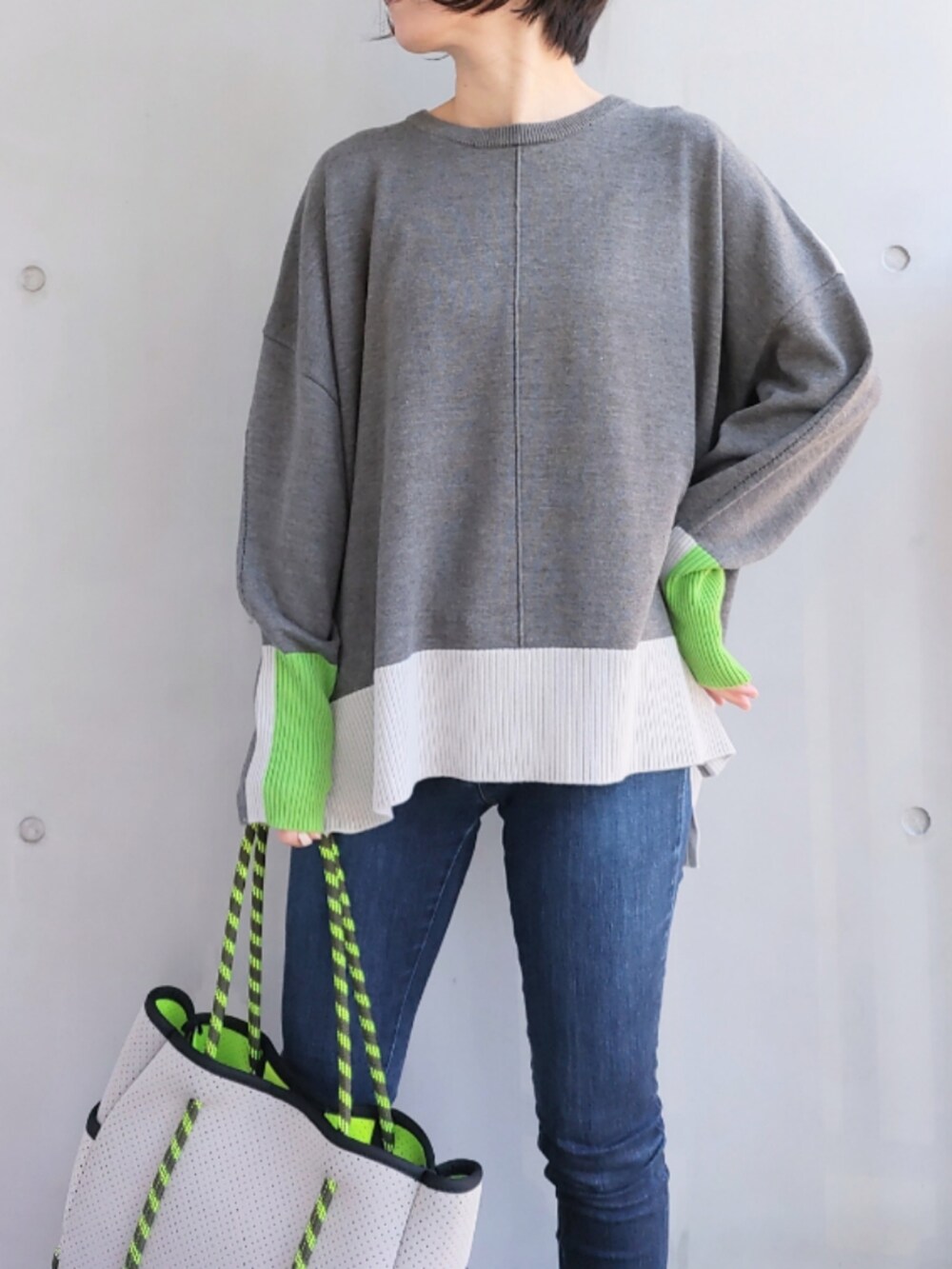 グレー系のトートバッグ、ブルー系のデニムパンツ、グレー系のニット/セーターを着用したレディースの冬コーディネートの3枚目の写真