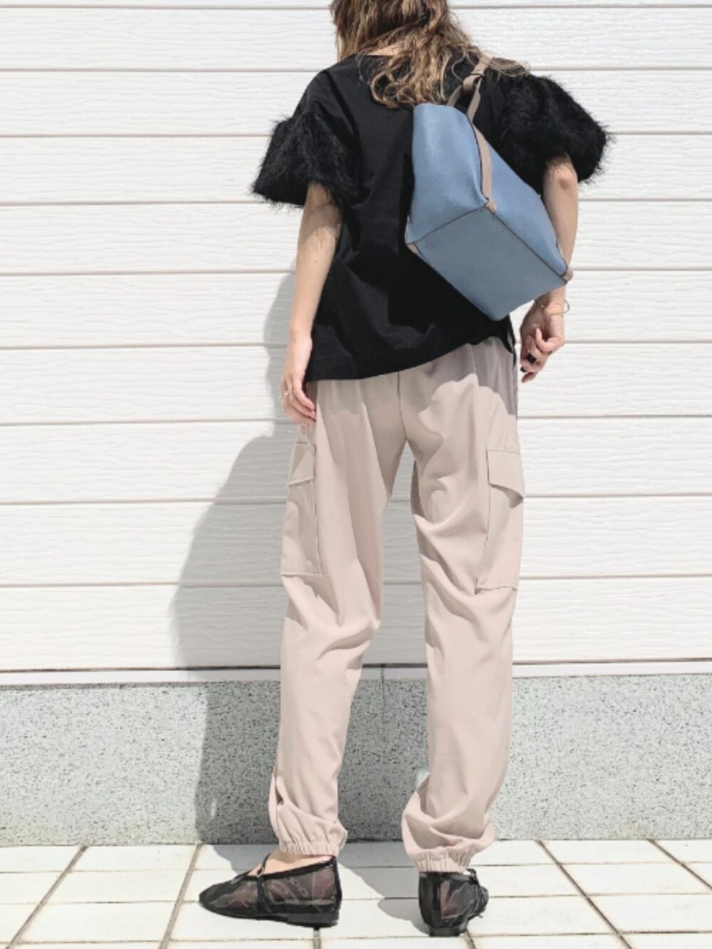 ベージュ系のカーゴパンツ、ブラック系のTシャツ/カットソー、ブルー系のトートバッグを着用したレディースの春コーディネートの3枚目の写真