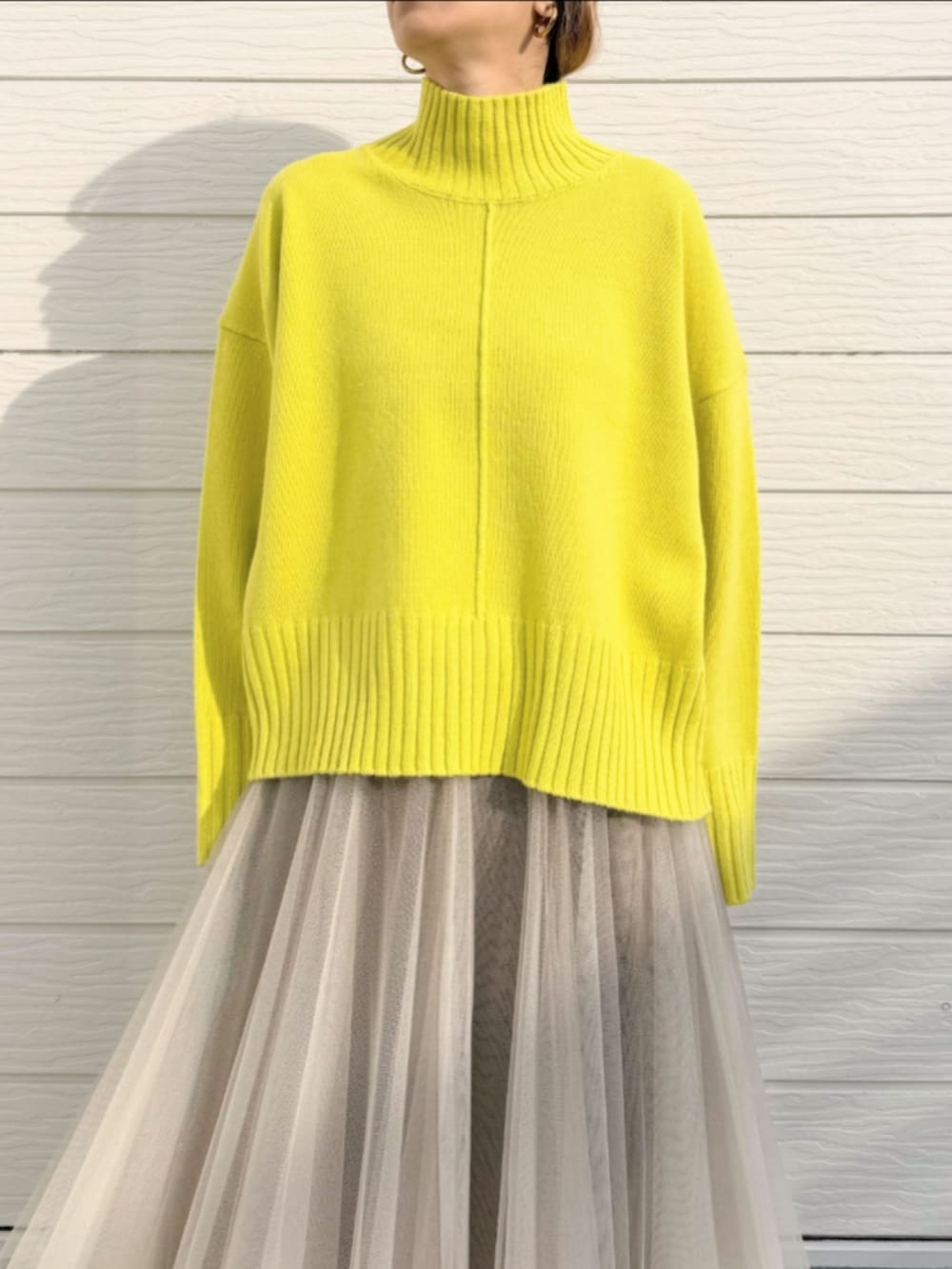 ゴールド系のスカート、グリーン系のニット/セーターを着用したレディースの冬コーディネートの5枚目の写真