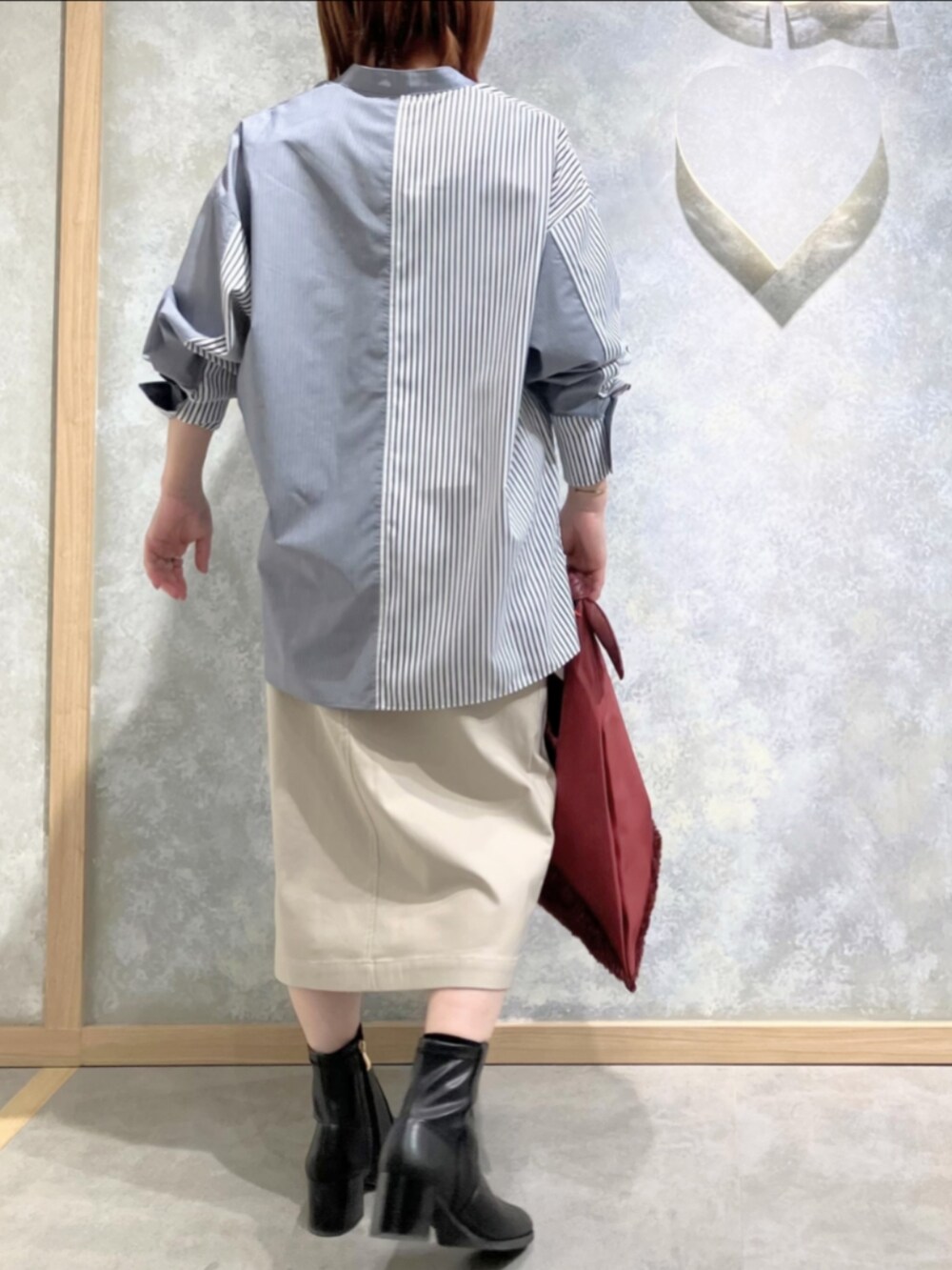 レッド系のトートバッグ、ベージュ系のスカート、ブルー系のシャツ/ブラウスを着用したレディースの冬コーディネートの4枚目の写真