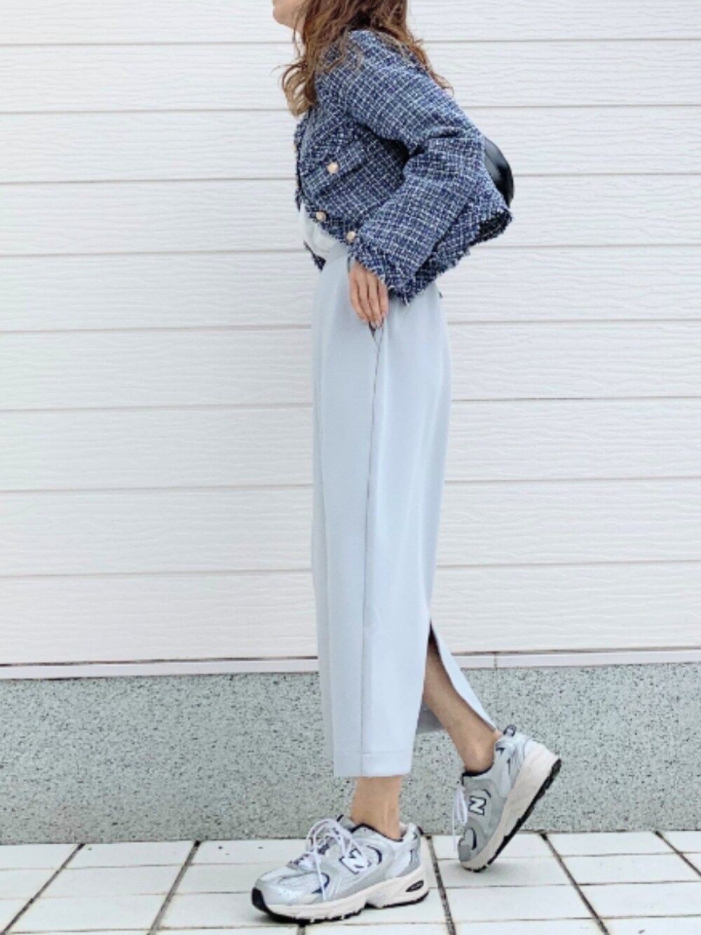 シルバー系のスニーカー、ホワイト系のTシャツ/カットソー、グリーン系のスカートを着用したレディースの冬コーディネートの2枚目の写真