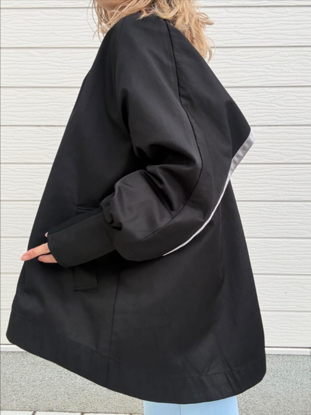 ブルー系のデニムパンツ、ブラック系のブルゾン、ブラック系のキャップを着用したレディースの冬コーディネートの4枚目の写真