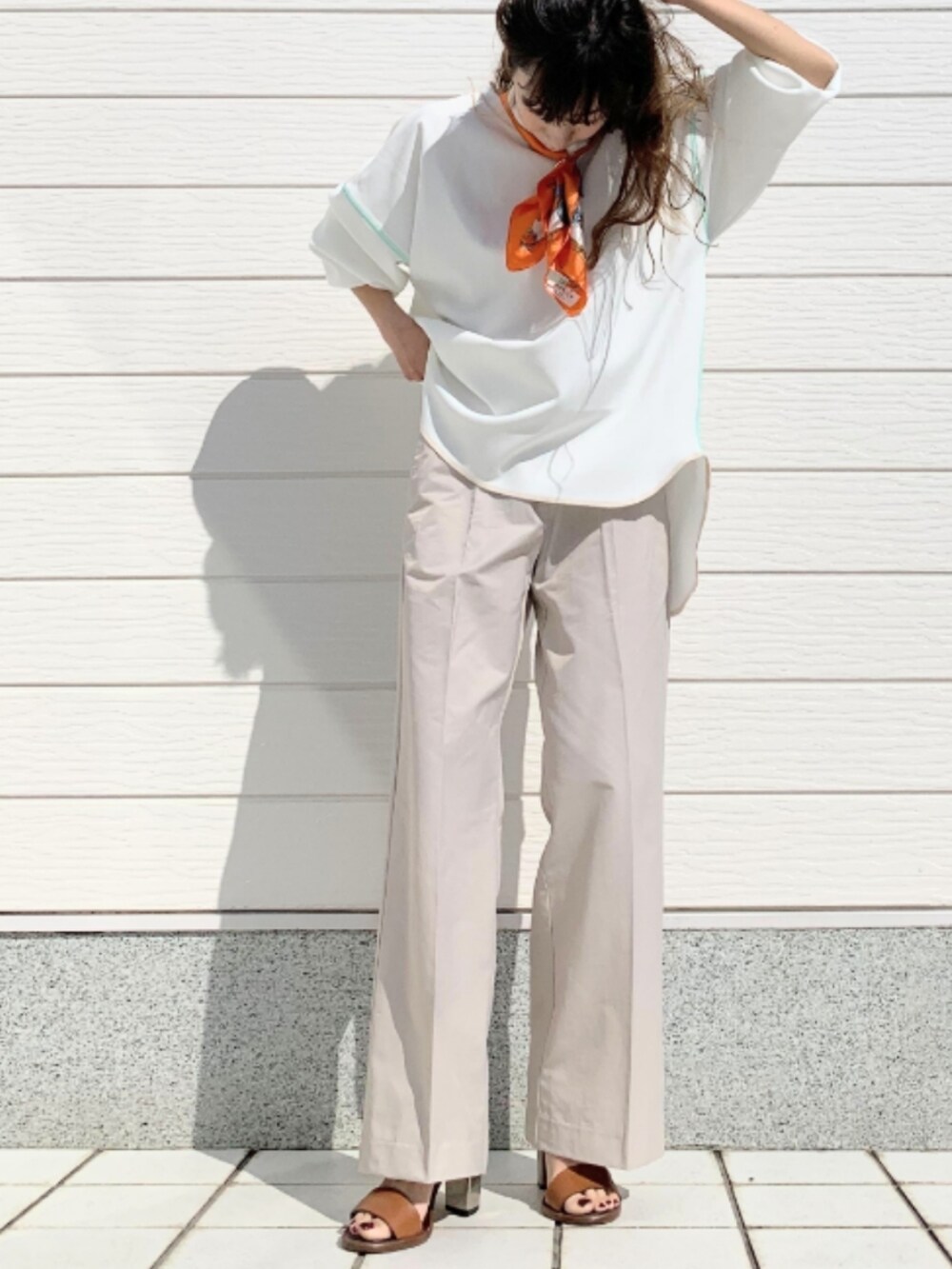 ホワイト系のTシャツ/カットソー、ブラック系のトートバッグ、ブラウン系のサンダルを着用したレディースの春コーディネートの2枚目の写真