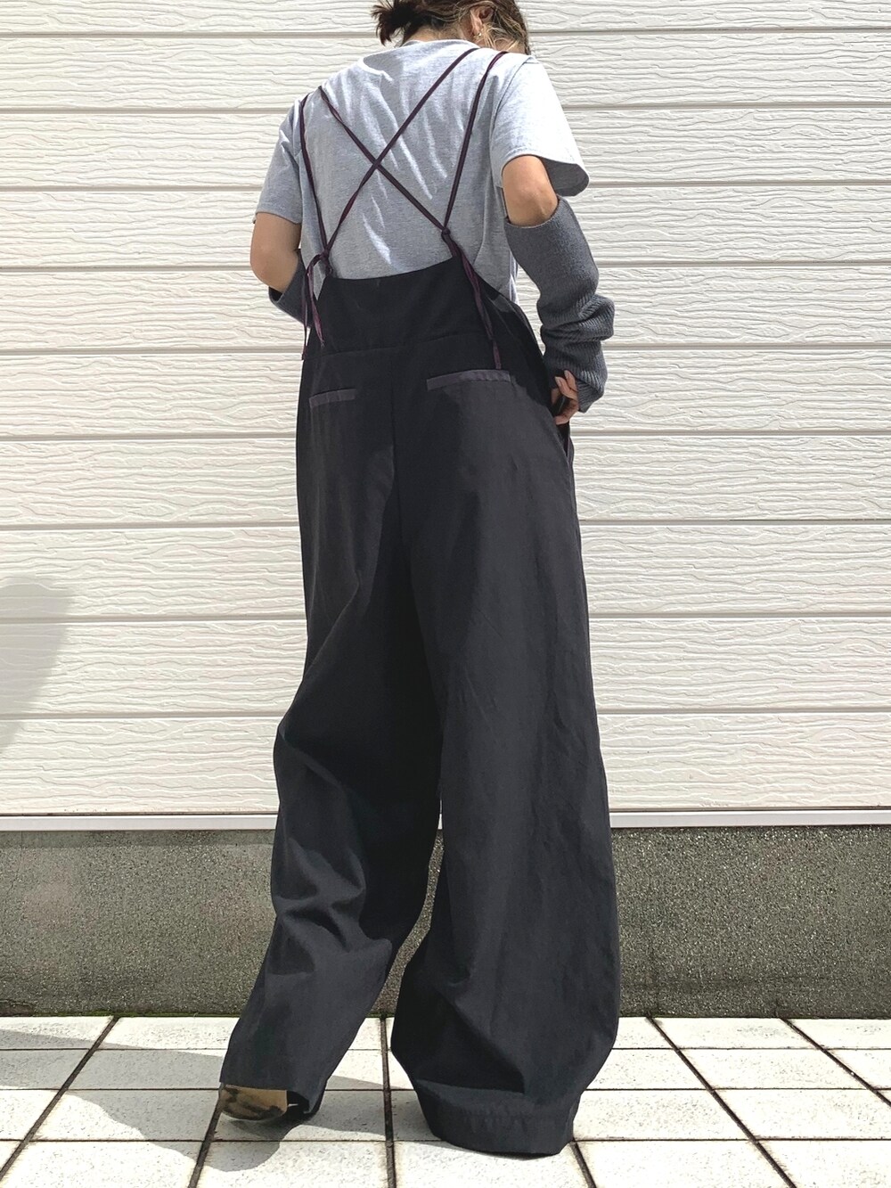 グレー系のTシャツ/カットソー、ブラック系のサロペット/オーバーオール、グレー系のアームカバーを着用したレディースの秋コーディネートの2枚目の写真