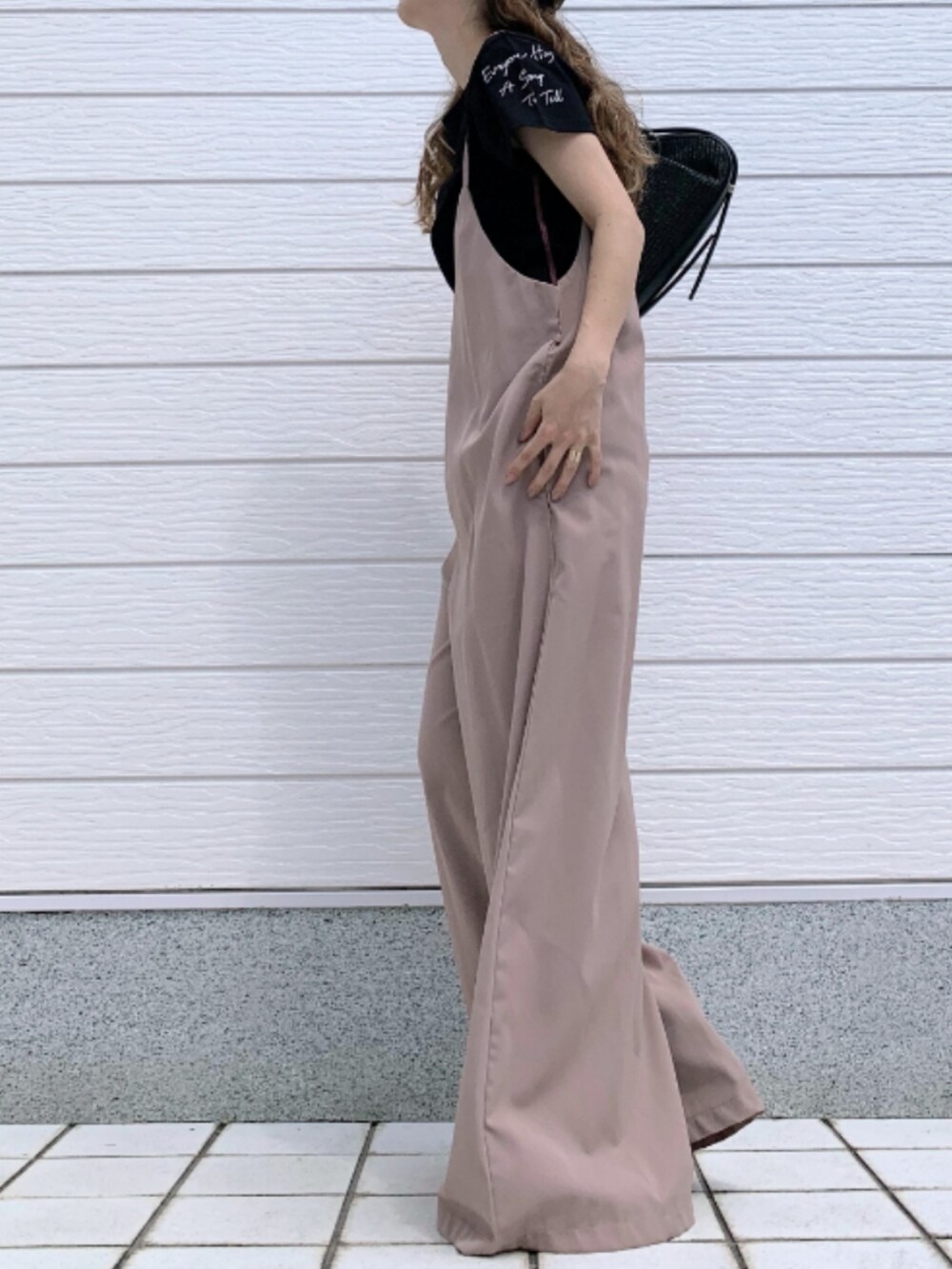 ブラウン系のサンダル、ブラック系のTシャツ/カットソー、ベージュ系のサロペット/オーバーオールを着用したレディースの春コーディネートの2枚目の写真