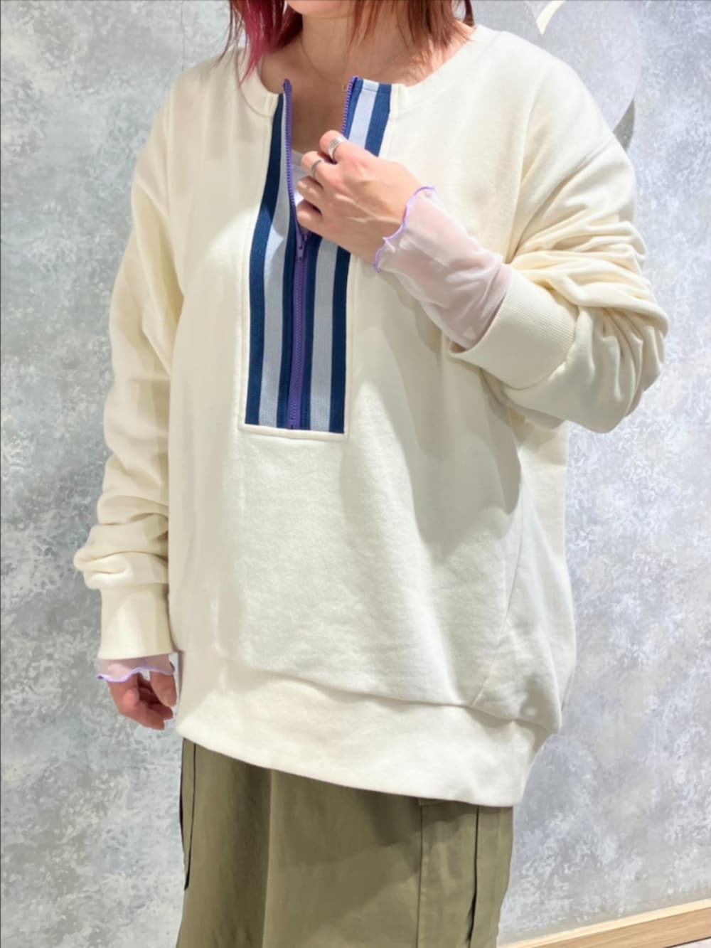 グリーン系のスカート、ホワイト系のスウェット、ホワイト系のブーツを着用したレディースの秋コーディネートの4枚目の写真