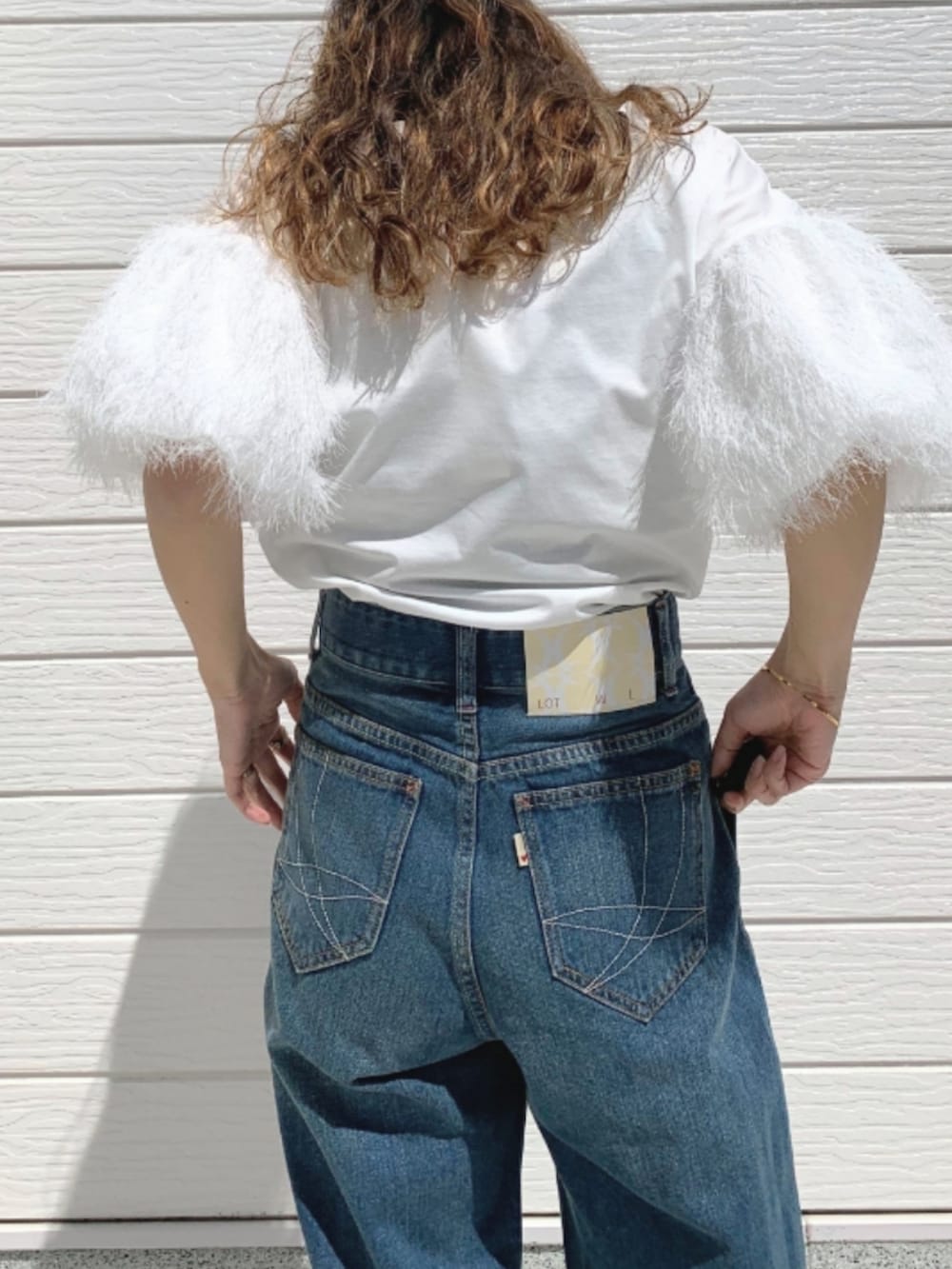 ホワイト系のTシャツ/カットソー、ゴールド系のトートバッグ、ブラック系のパンプスを着用したレディースの春コーディネートの4枚目の写真