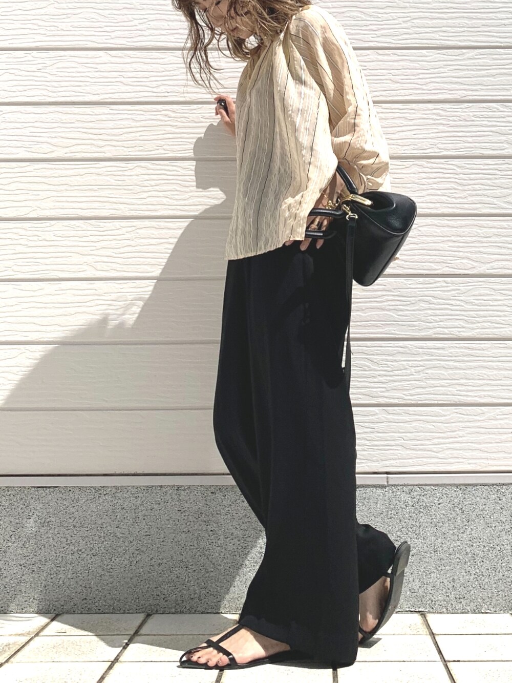 ブラック系のその他パンツ、ブラック系のショルダーバッグ、ベージュ系のシャツ/ブラウスを着用したレディースの春コーディネートの2枚目の写真