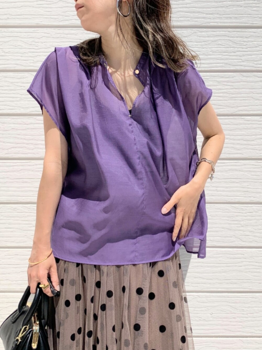 ブラウン系のスカート、ブラック系のショルダーバッグ、パープル系のシャツ/ブラウスを着用したレディースの春コーディネートの4枚目の写真