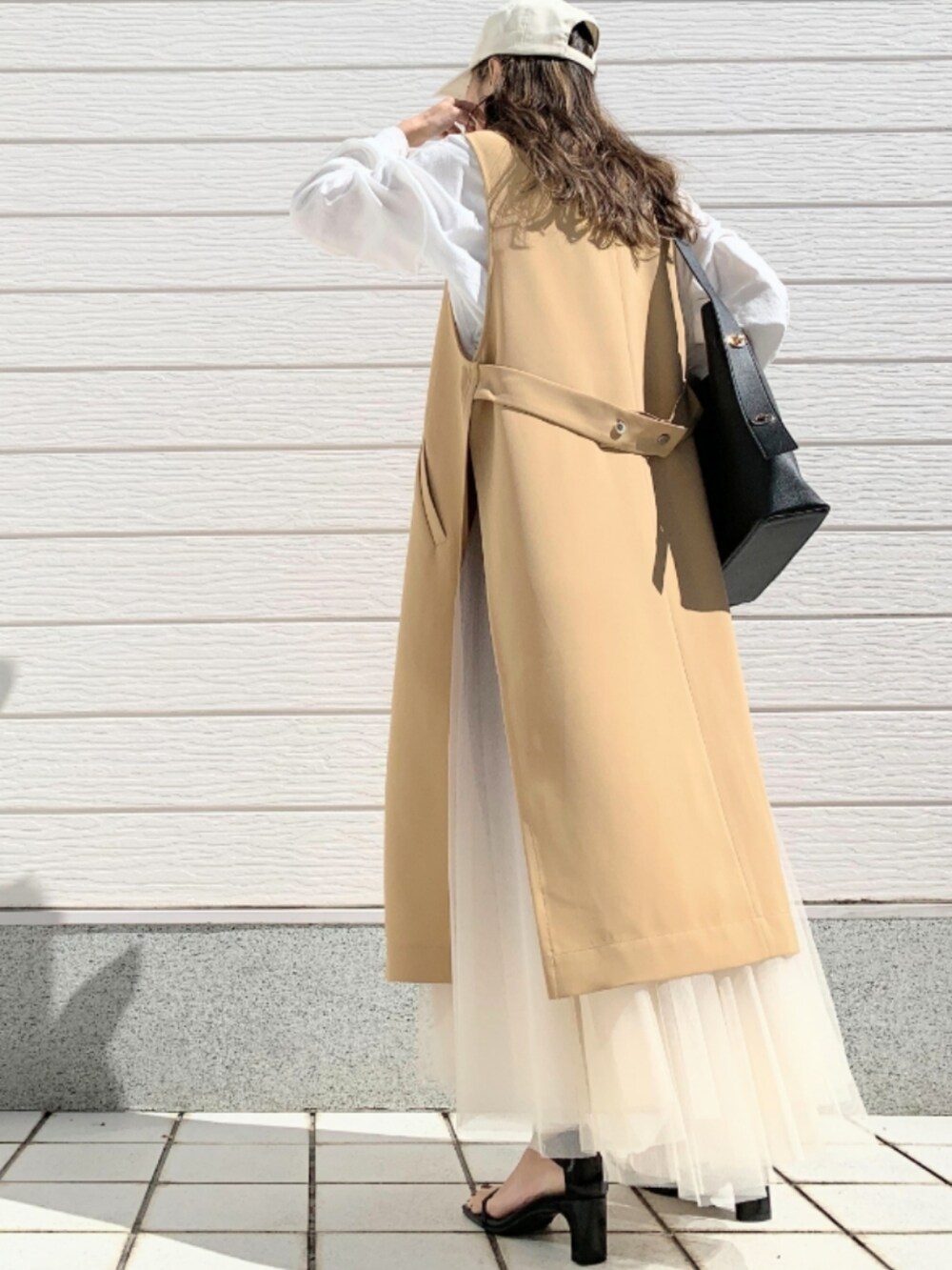 ホワイト系のTシャツ/カットソー、ブラック系のトートバッグ、ゴールド系のスカートを着用したレディースの春コーディネートの3枚目の写真