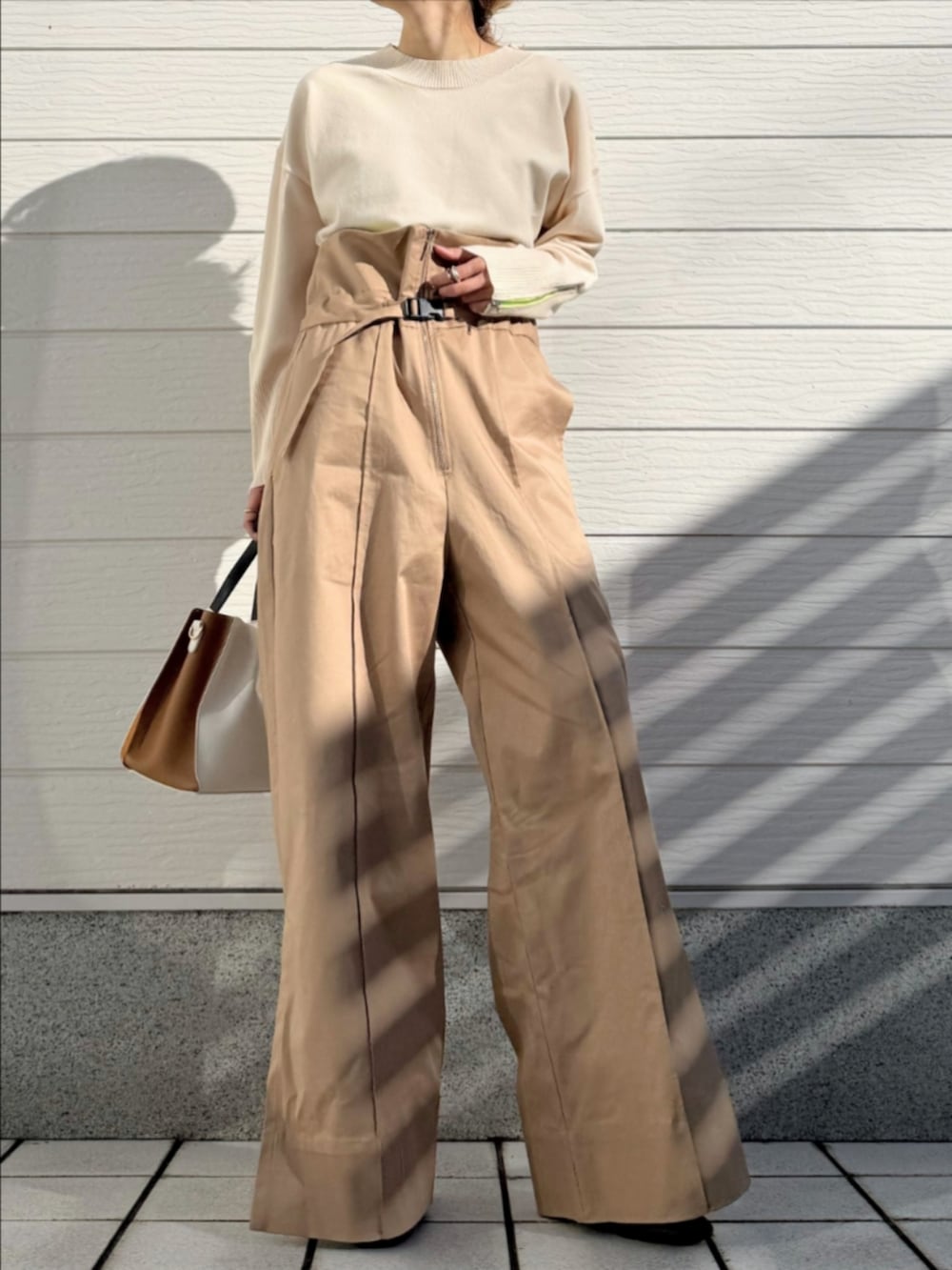 ホワイト系のスニーカー、ホワイト系のニット/セーター、ベージュ系のその他パンツを着用したレディースの冬コーディネートの2枚目の写真