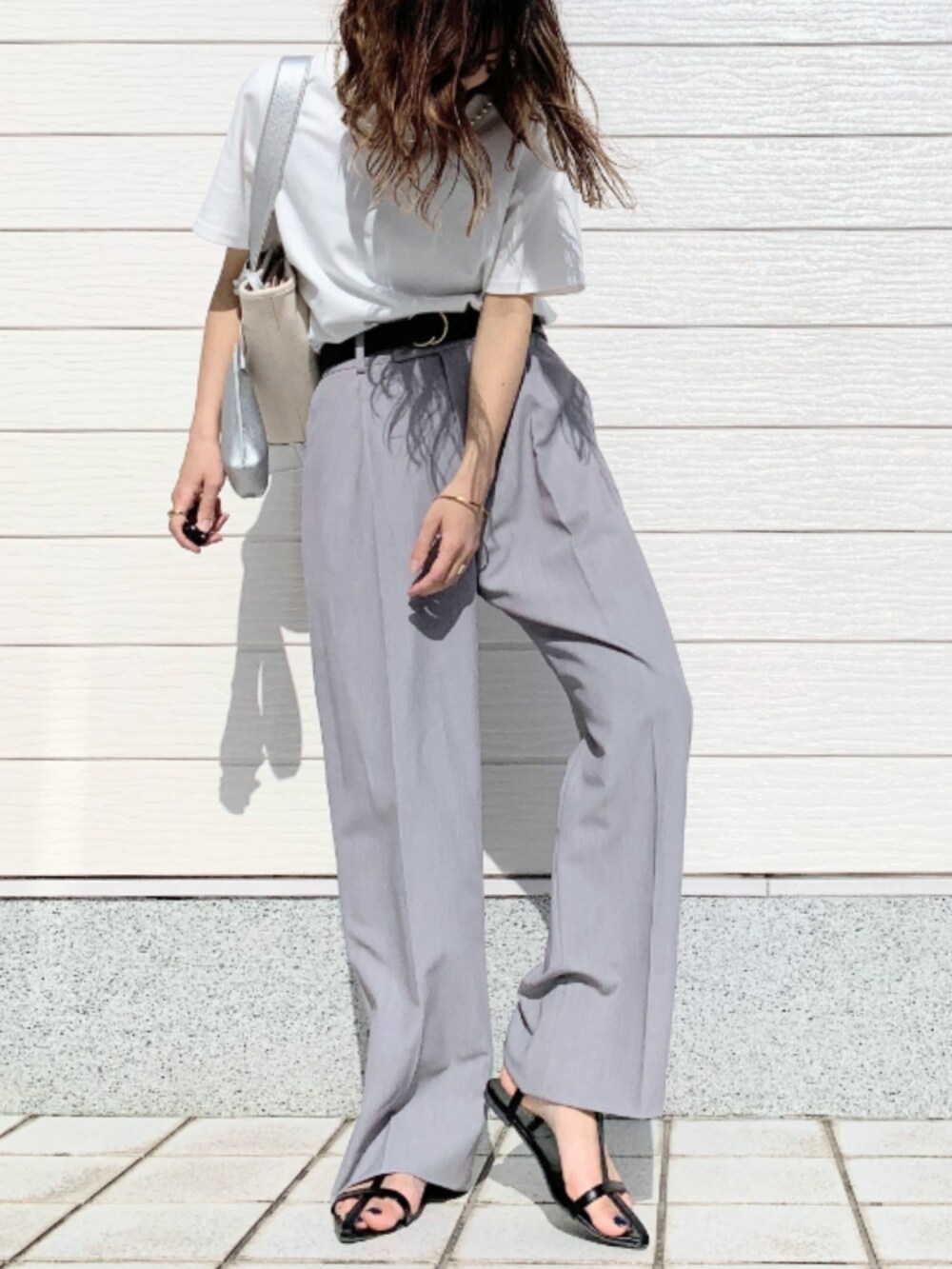 グレー系のその他パンツ、ホワイト系のTシャツ/カットソー、シルバー系のハンドバッグを着用したレディースの春コーディネートの2枚目の写真