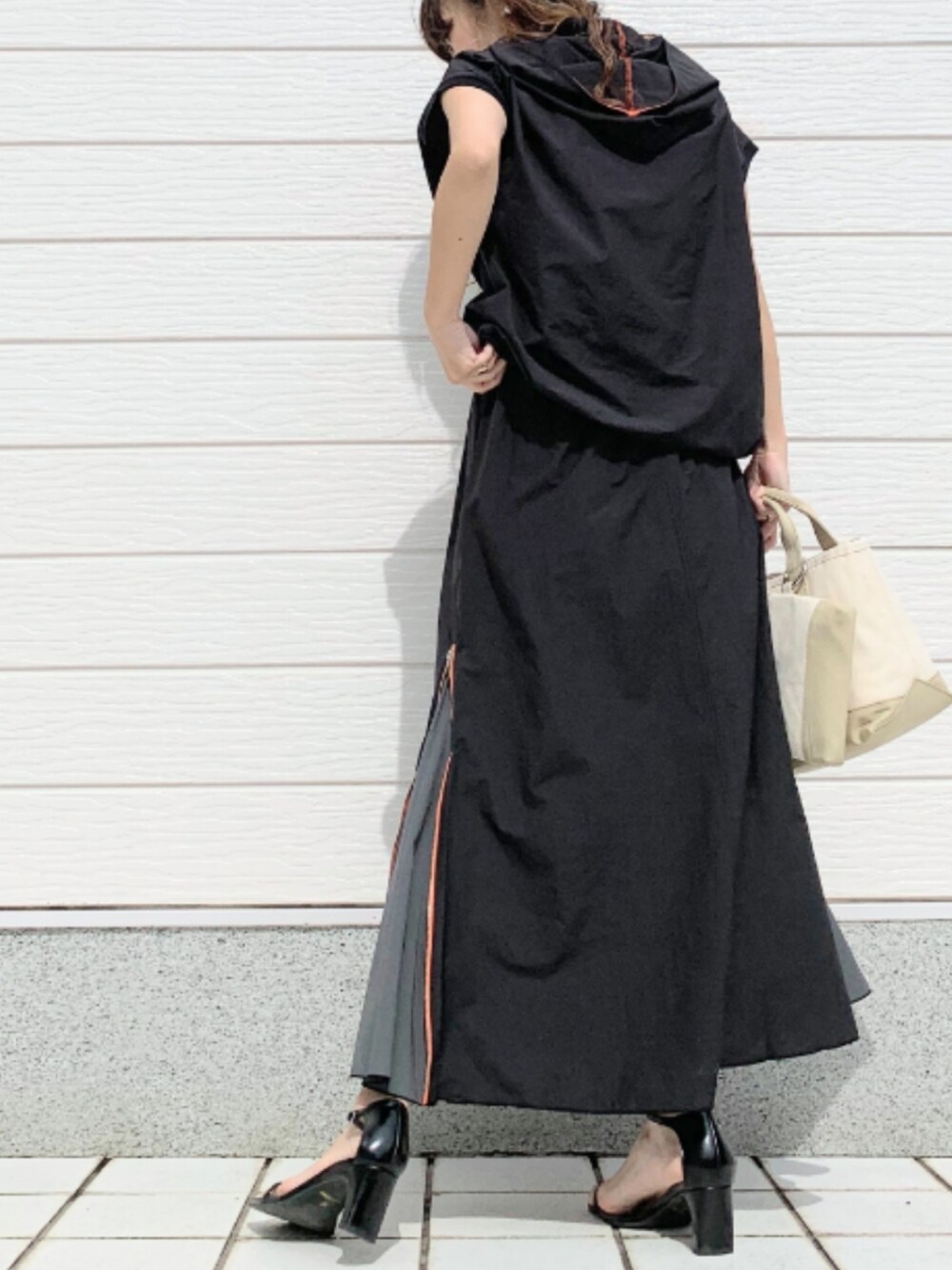 ベージュ系のトートバッグ、ブラック系のスカートを着用したレディースの夏コーディネートの4枚目の写真