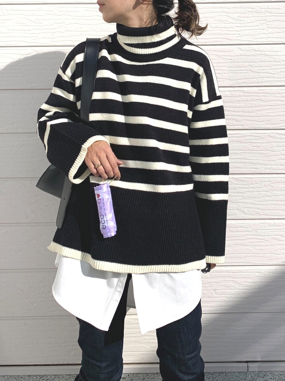 ブラック系のブーツ、ブルー系のデニムパンツ、ホワイト系のシャツ/ブラウスを着用したレディースの冬コーディネートの4枚目の写真