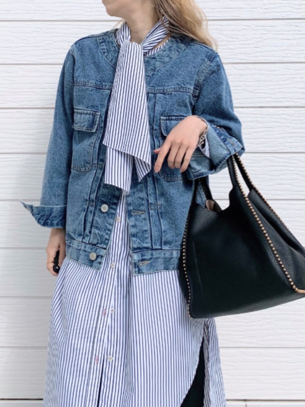 ブラック系のトートバッグ、ブルー系のその他パンツ、ブルー系のデニムジャケットを着用したレディースの春コーディネートの3枚目の写真