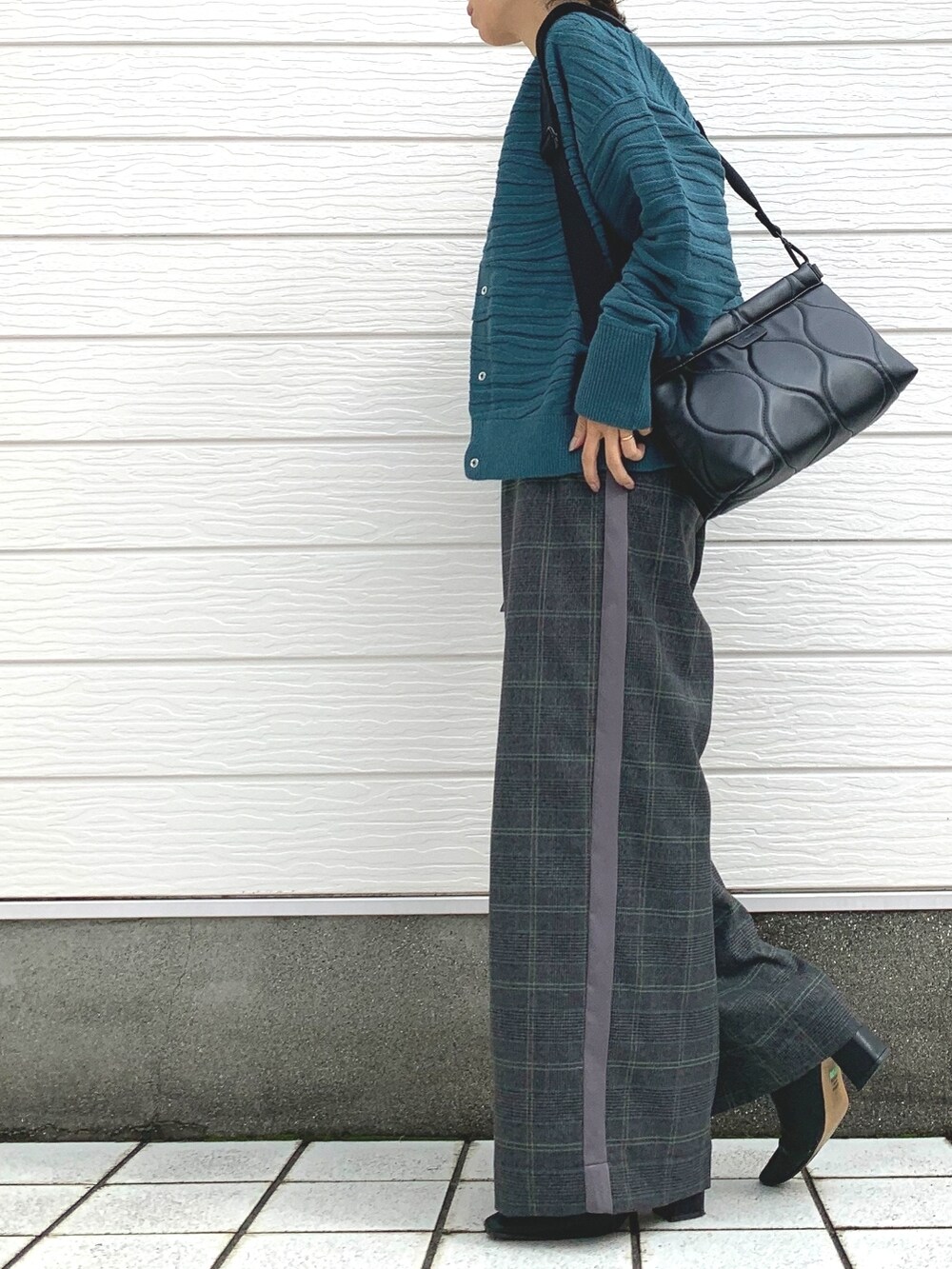 グリーン系のカーディガン/ボレロ、ホワイト系のTシャツ/カットソー、ブラック系のクラッチバッグを着用したレディースの秋コーディネートの2枚目の写真