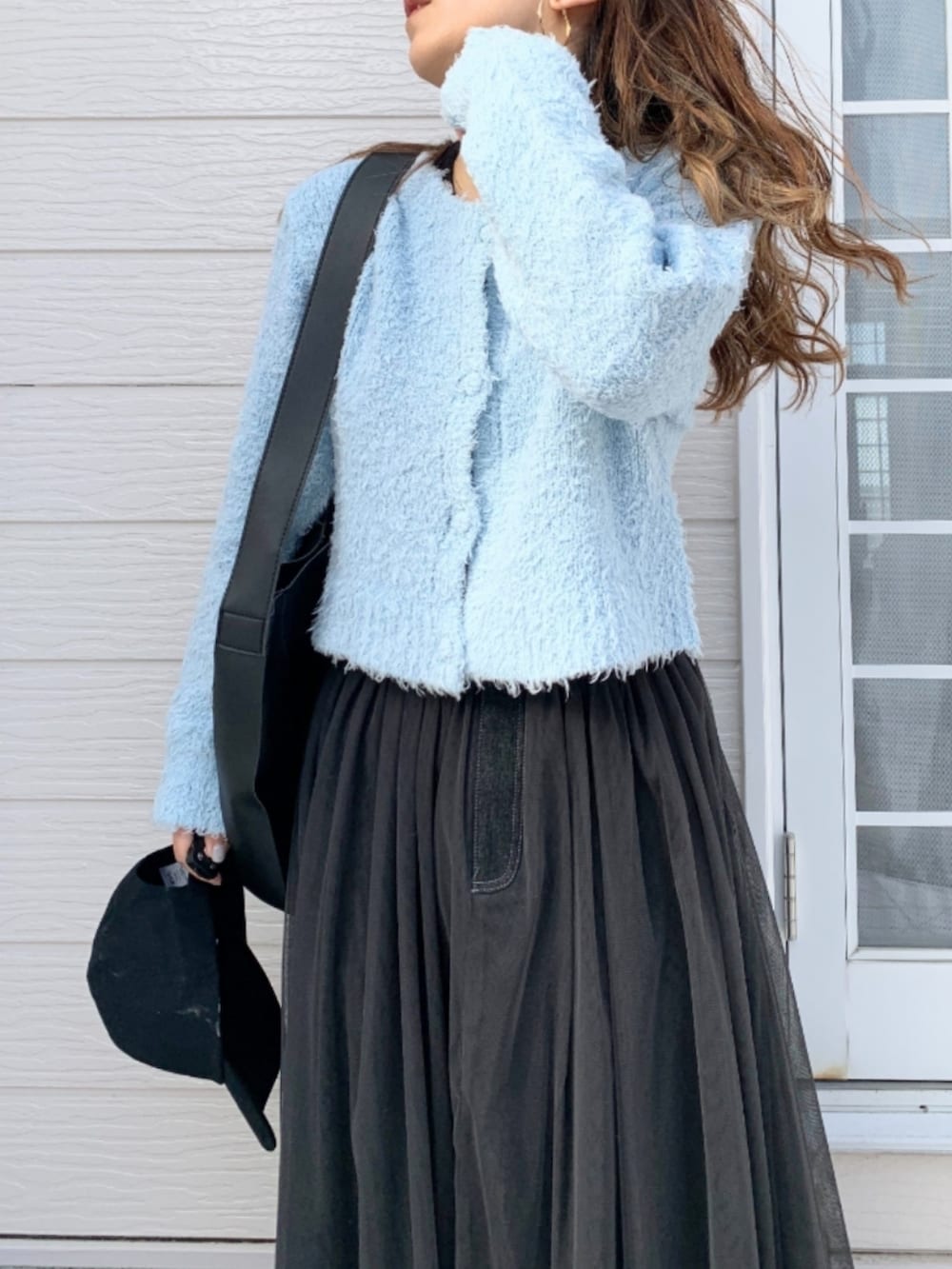 グレー系のスカート、シルバー系のスニーカー、ブルー系のカーディガン/ボレロを着用したレディースの冬コーディネートの3枚目の写真